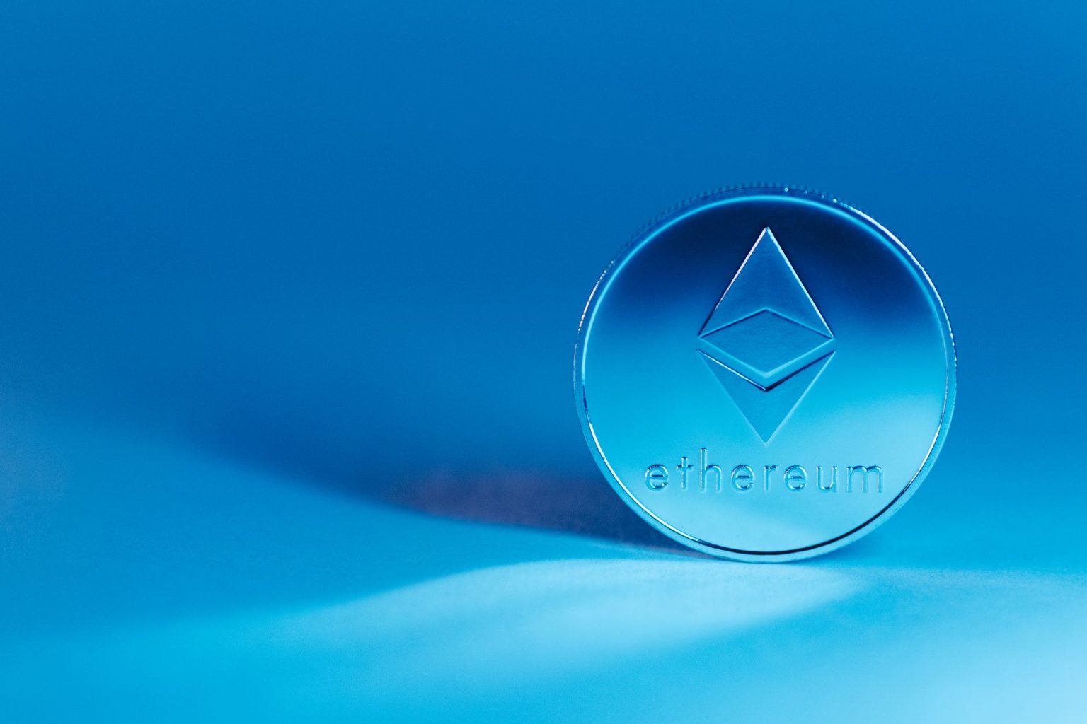 Moeda com o símbolo do Ethereum sobre fundo azul.