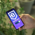 Pessoa segura um smartphone que exibe uma interface de aplicativo de blockchain.