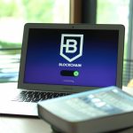 Laptop exibindo uma interface digital com conexões entre blocos de uma rede blockchain.
