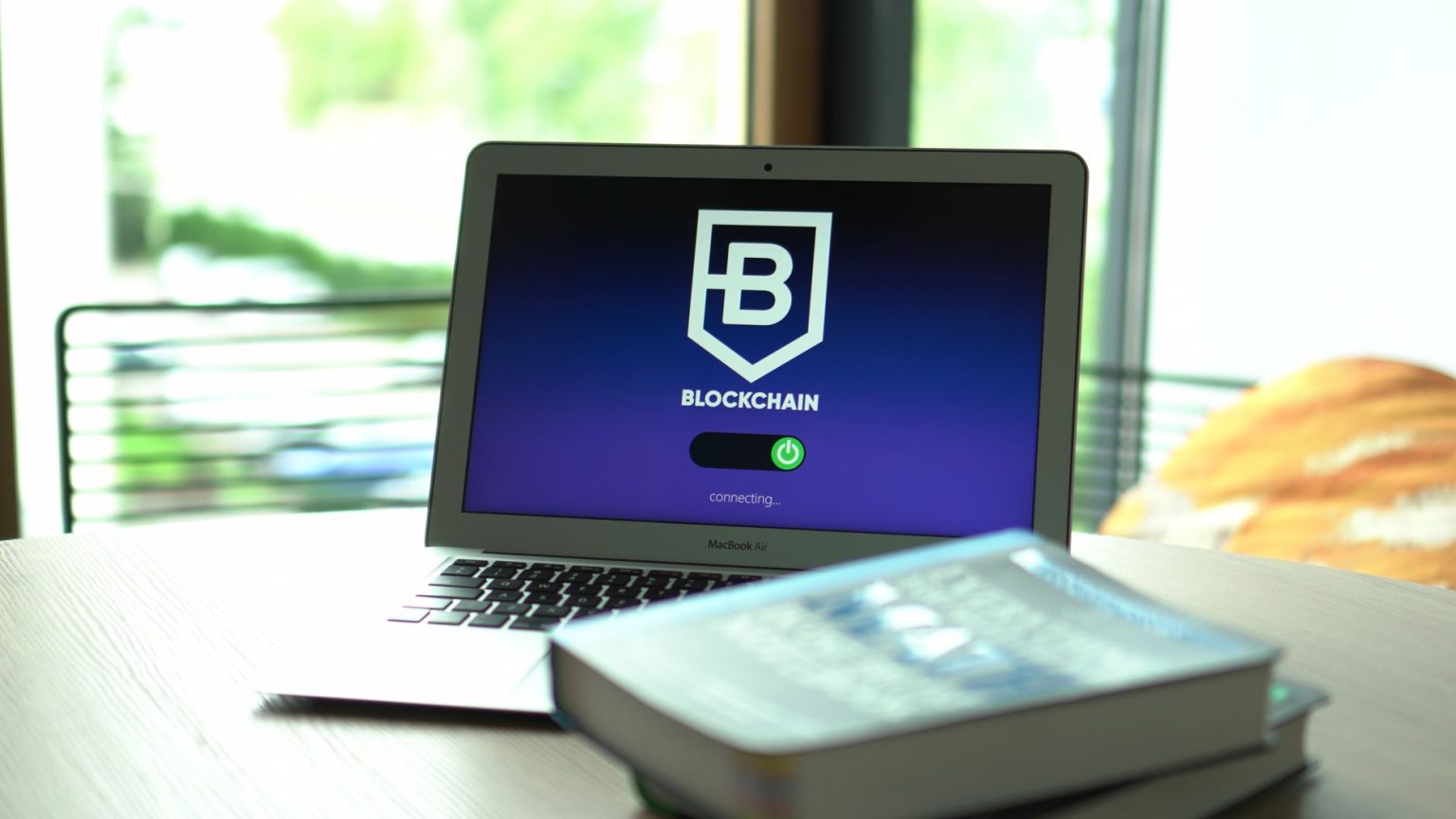Laptop exibindo uma interface digital com conexões entre blocos de uma rede blockchain.